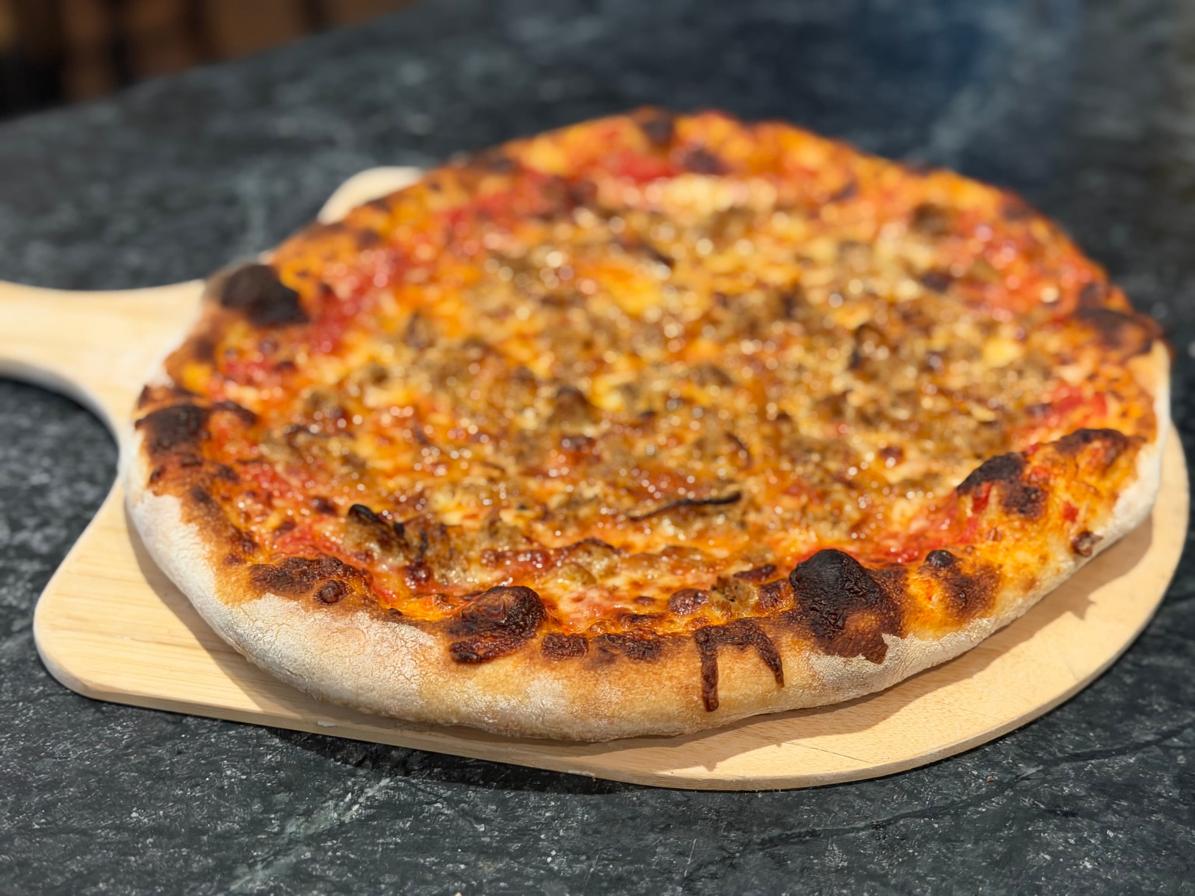Artisan pizza on wooden peel